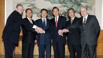 Negocjatorzy z sześciu krajów podają sobie ręce