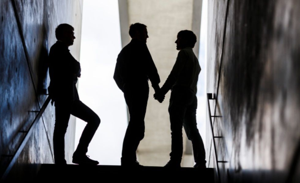BERLIN, GERMANY - AUGUST 12: (EDITOR'S NOTE: In this photo illustration)Two men pose for a photo during walking up stairs hand in hand next to a third man on August 12, 2014 in Berlin, Germany.
(Photo Illustration by Thomas Trutschel/Photothek via Getty Images) 