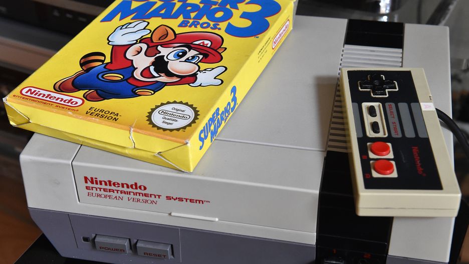 Konsola Nintendo z lat 80-tych wraz z grą "Super Mario Bros. 3"