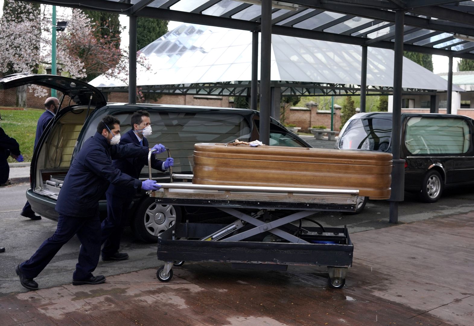 Pracownicy kostnicy w Madrycie z trumną osoby, która zmarła na koronawirusa.