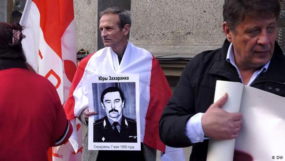 Demonstrant z plakatem ze zdjęciem byłego ministra spraw zagranicznych Jurija Zacharienki