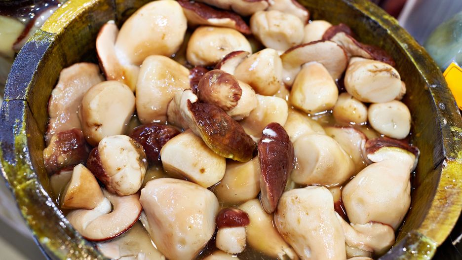 Salted white mushrooms on wooden barrel