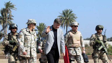 Minister obrony Polski Jerzy Szmajdziński w otoczeniu oficerów i ochrony po przylocie do obozu Babilon w Iraku