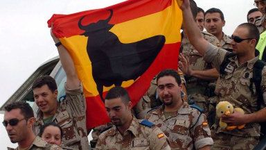 Wracający z Iraku hiszpańscy żołnierze, niosą hiszpańską flagę z czarnym bykiem