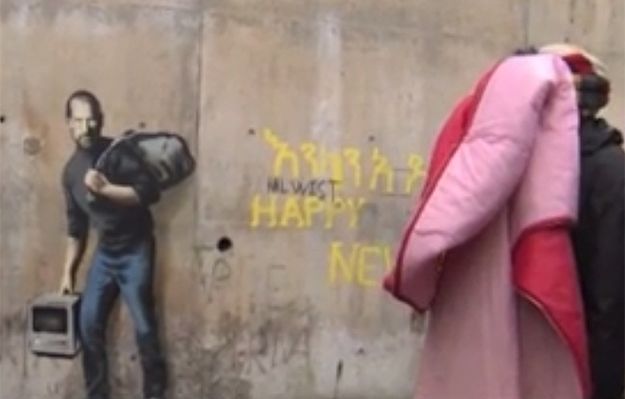 Uchodźcy w Calais zarabiają na muralu Banksy'ego