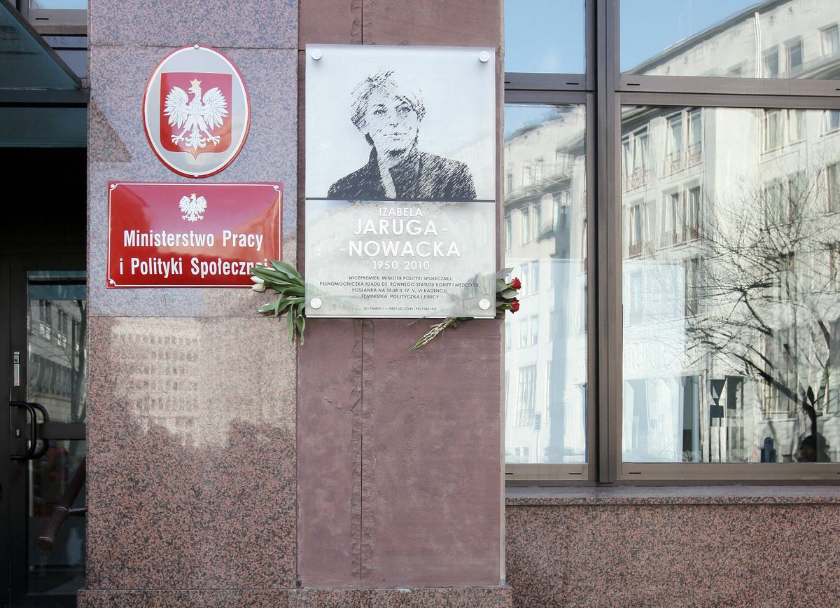Zniszczona tablica upamiętniająca Izabelę Jarugę-Nowacką. Wisi na ścianie ministerstwa