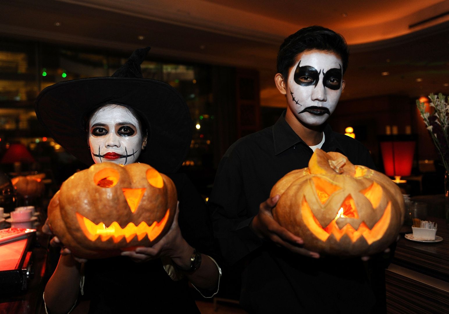 SURABAYA, INDONESIA - OCTOBER 31:  Revelers pose with jack-o'-lanterns at a Halloween party at Sheraton Surabaya Hotel on October 31, 2013 in Surabaya, Indonesia.  Revelers across the country are celebrating Halloween the day before the Christian All Saints' Day, which  honors the dead.  (Photo by Robertus Pudyanto/Getty Images)