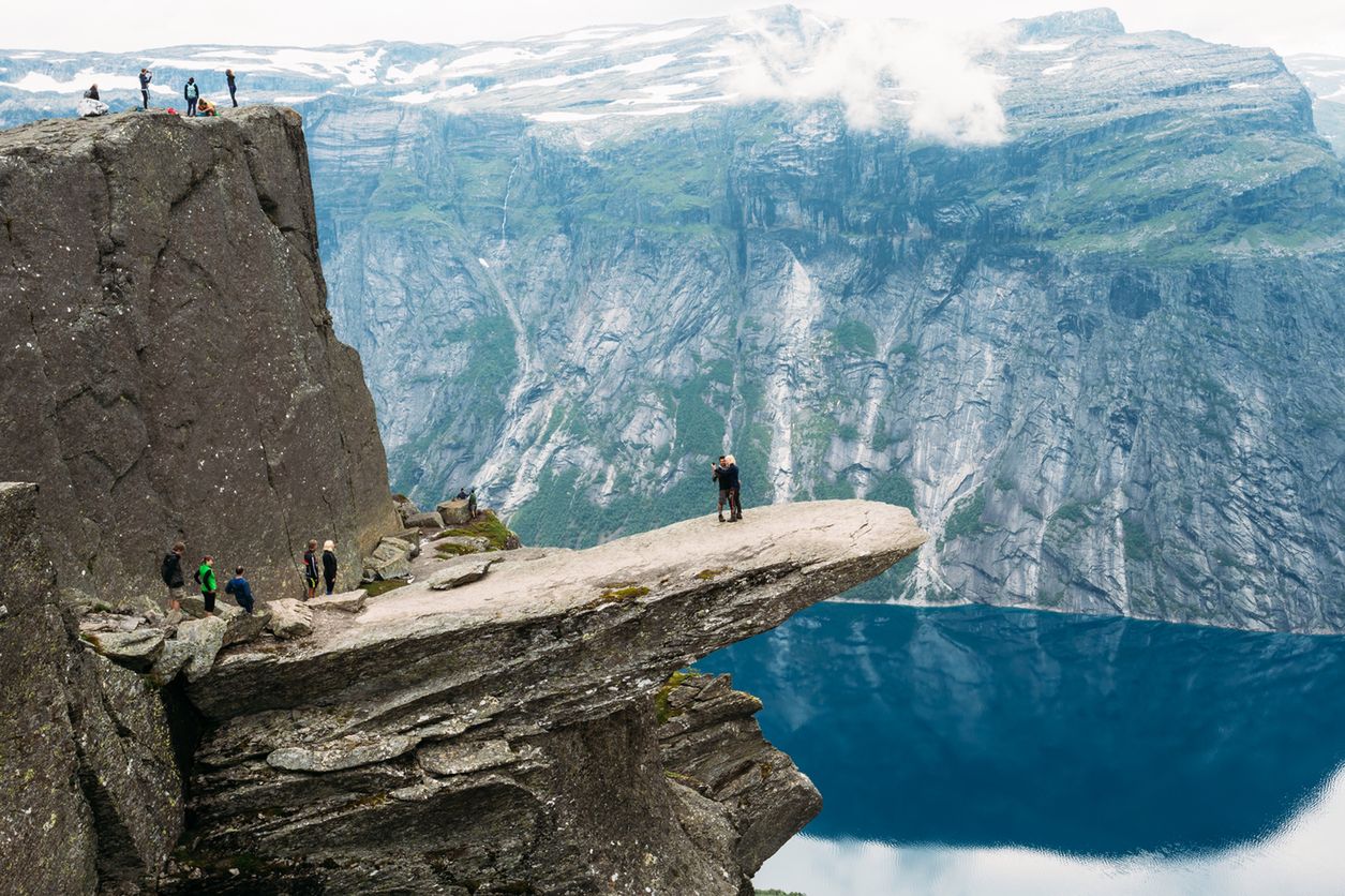 Odda, Norway - August 04, 2014: Young People Are Photographed Standing On A Rock Trolltunga - Troll Tongue In Norway 