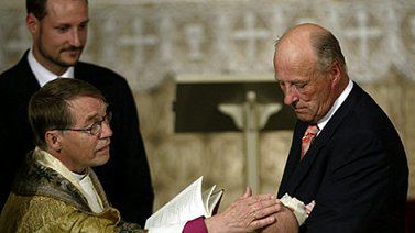 Król Harold trzyma wnuczkę do chrztu