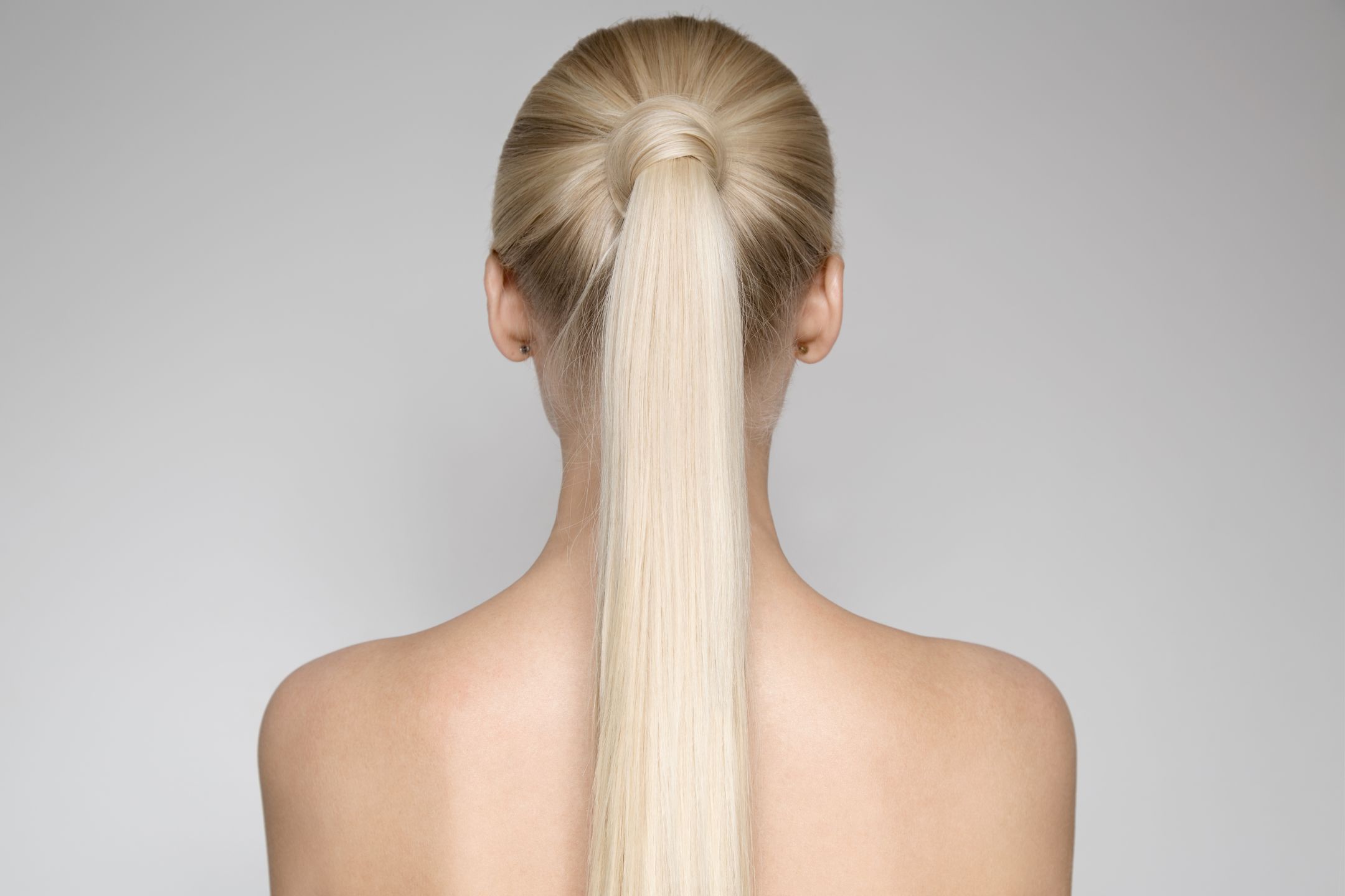 Portrait Of A Beautiful Young Blond Woman With Ponytail Hairst��le. Back view 