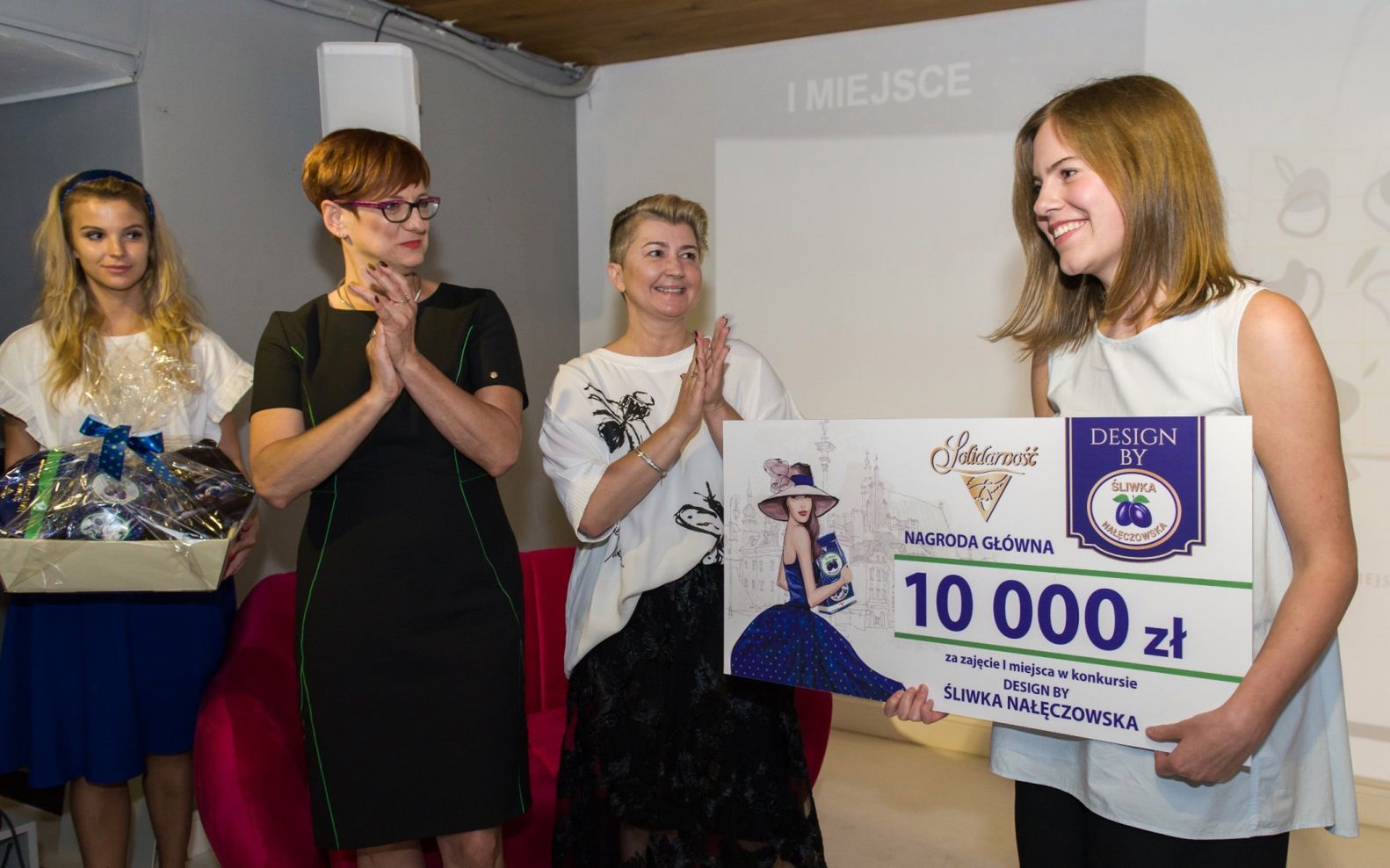 Zadaniem było zaprojektowanie spójnych graficznie projektów nadruku na kubek, płócienną torbę i apaszkę, inspirowanych projektem opakowania Śliwki Nałęczowskiej