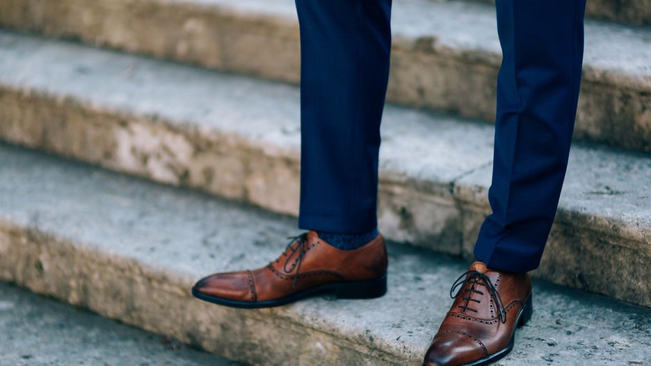 Brązowe buty idealnie pasują do granatowych spodni