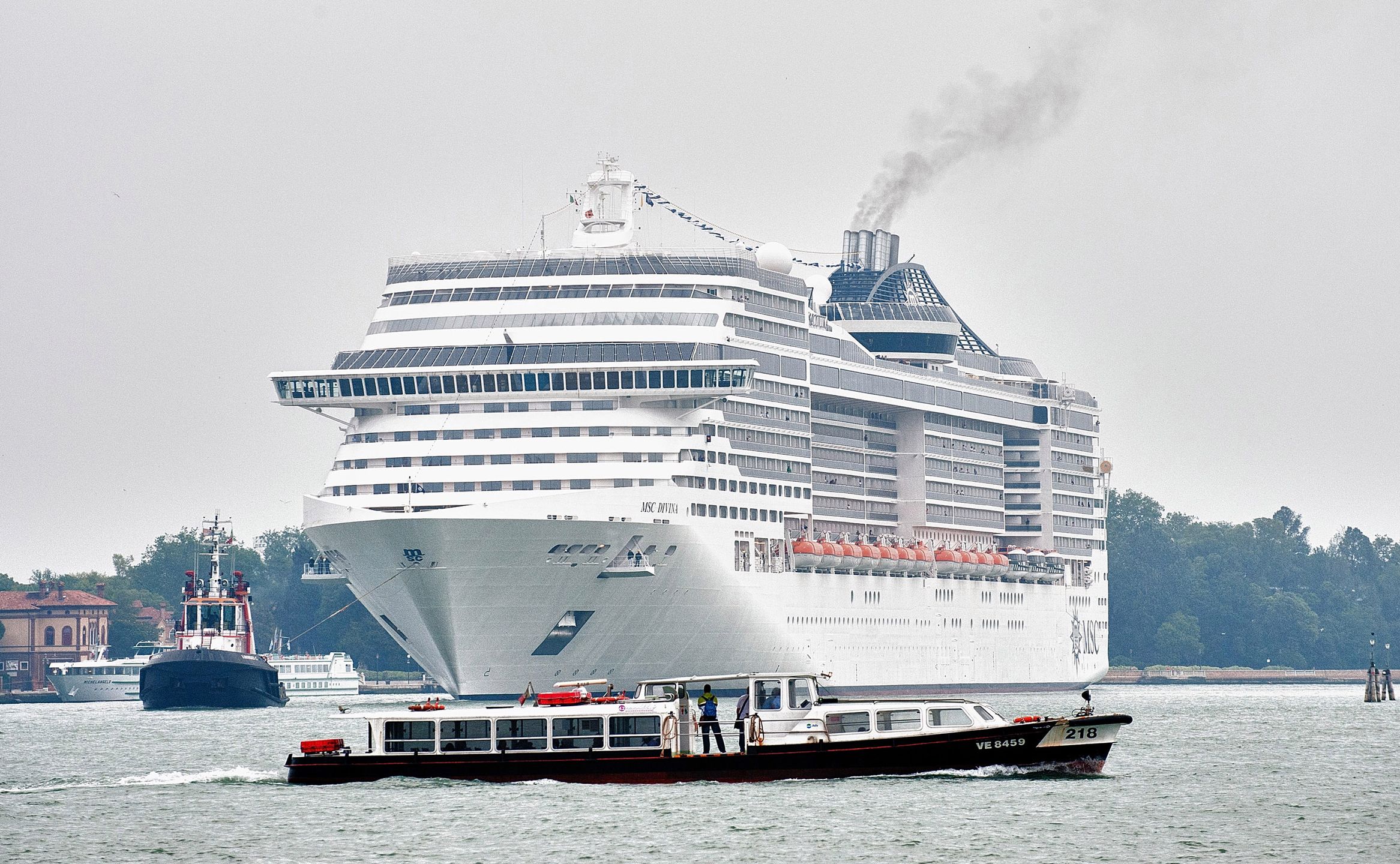 VENICE, ITALY - JUNE 02:  A waterbus cross the way toÊ MSC Divina while she enters St Mark's basin with 139,000 Tonns and nearly 4,000 passengers on June 2, 2012 in Venice, Italy. FAI (Fonto Ambientale Italiano) is now supporting Venetians and environmentalists in their protetst against cruise ships sailing in St Mark's basin, stressing that the increased boat traffic on Venice's waterways increases pollution and damages property.  (Photo by Marco Secchi/Getty Images)