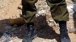 Izraelski żołnierz pilnuje ciała palestyńskiego bojownika, zastrzelonego podczas palestyńskiego ataku