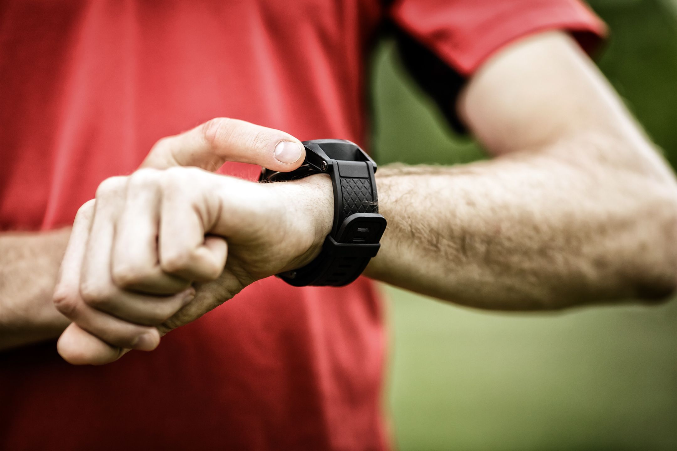 Runner on mountain trail looking at smartwatch or sport watch, checking gps navigation position map or heart rate pulse trace, using heart monitor equipment. Sport and fitness outdoors in nature. 