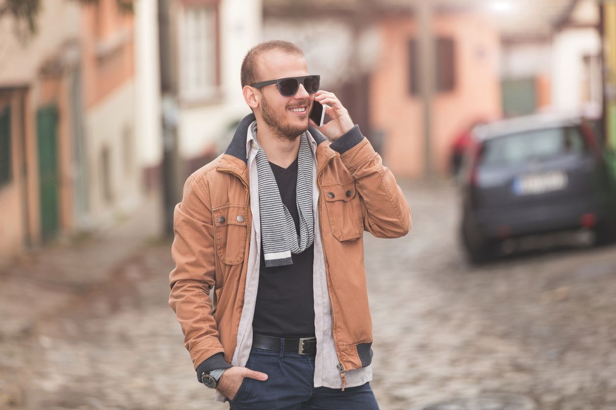 Modern guy using cellphone on the street. 