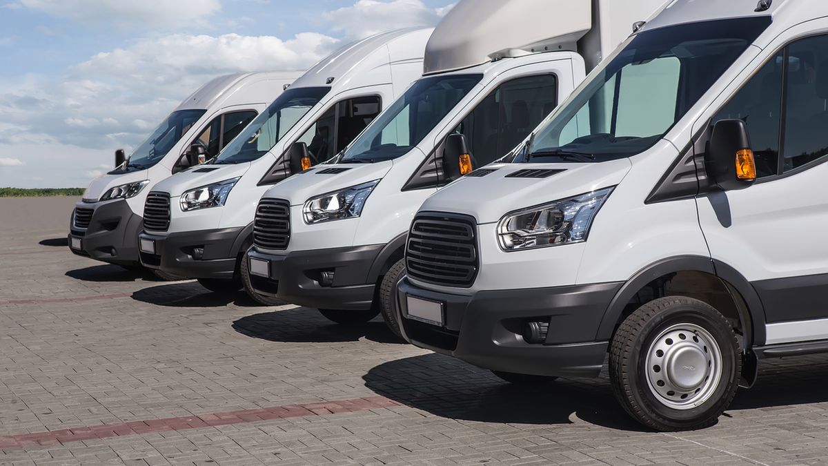 number of new white minibuses and vans outside