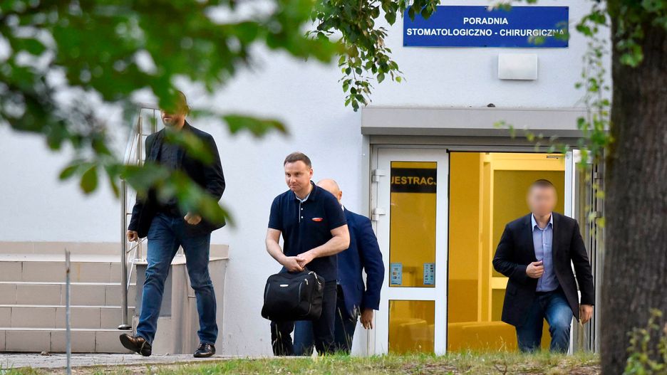 Prezydent Andrzej Duda wychodzący w towarzystwie ochroniarzy z poradni stomatologiczno-chirurgicznej