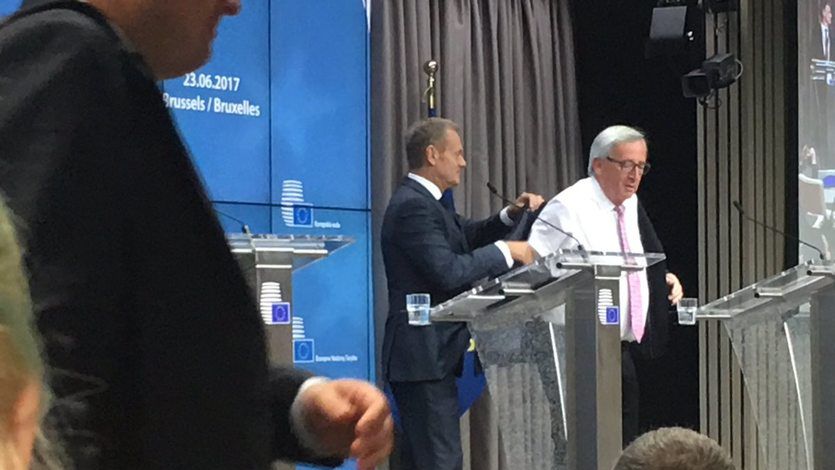 Donald Tusk pomaga założyć marynarkę Jeanowi-Claude'owi Junckerowi
