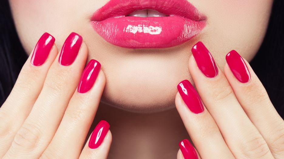 Makeup Lips with Pink Glossy Lipstick and Pink Nails. Shiny Lips and Hand with Manicure