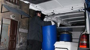 Pracownicy firmy pogrzebowej zabierają beczki do Zakładu Medycyny Sądowej