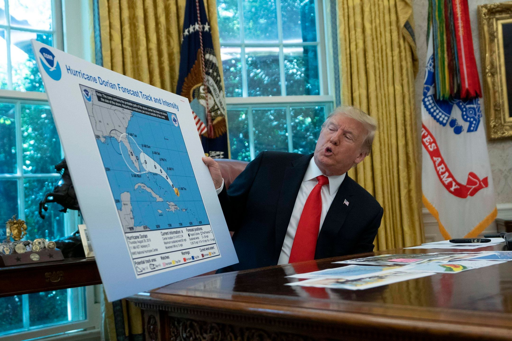 Donald Trump pokazuje aktywność huraganu na mapie Narodowej Służby Oceanicznej i Atmosferycznej z Alabamą dorysowaną markerem.
