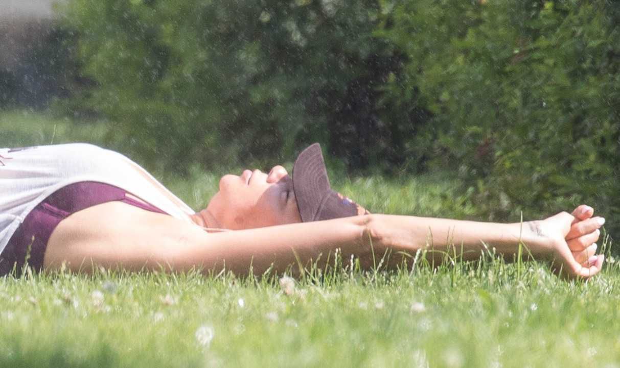 Edyta Górniak w szortach siedzi na trawie. Gwiazda przyłapana przez paparazzi
