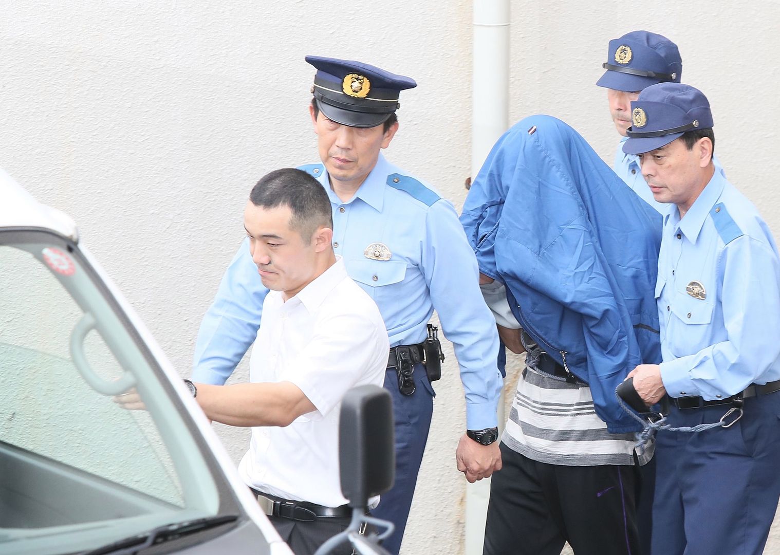 Japonia, Tokio. Satoshi Uematsu prowadzony przez policję.