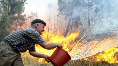 Mieszkaniec wioski Soito da Ruiva koło Arganil usiłuje walczyć z ogniem trawiącym las koło jego domu