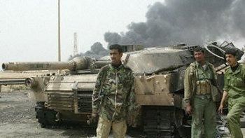 Żołnierze Saddama przy zniszczonym w Bagdadzie czołgu Abrams (Fot. AFP)