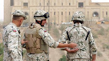 Płk Paweł Hejna prezentuje na żołnierzach kamizelki kuloodporne