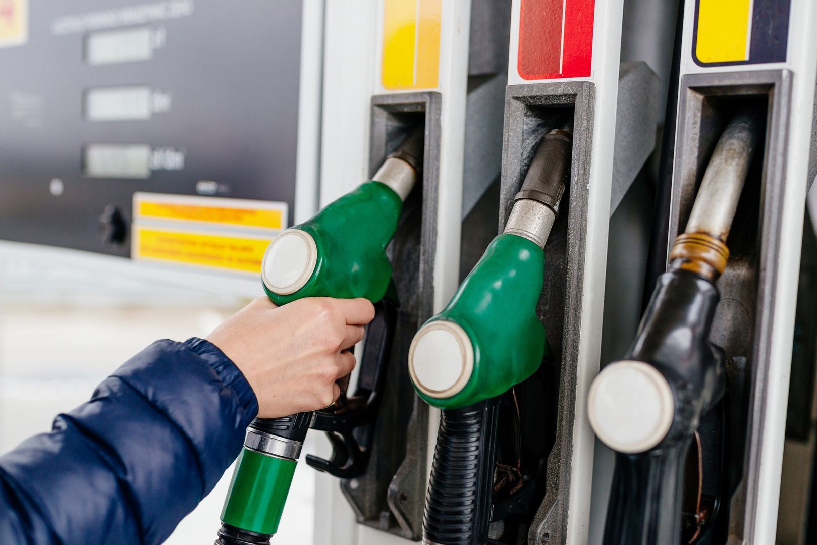 Woman holding a fuel nozzle on the gasoline station