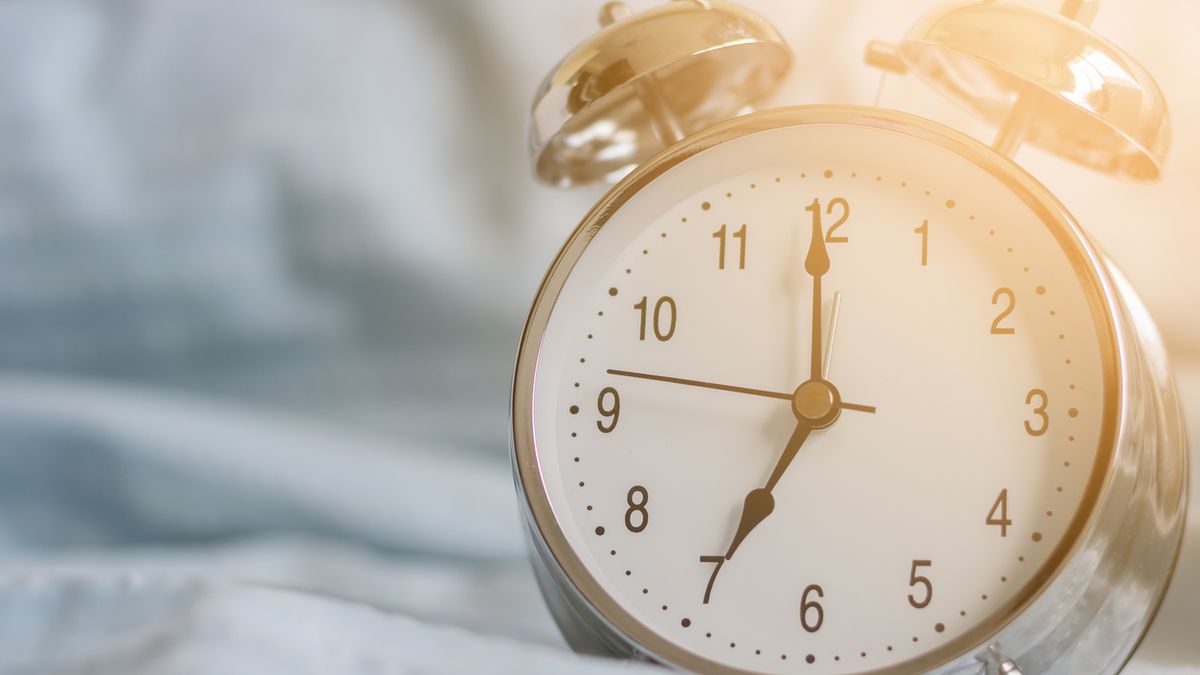 Clock on the bed in the morning.