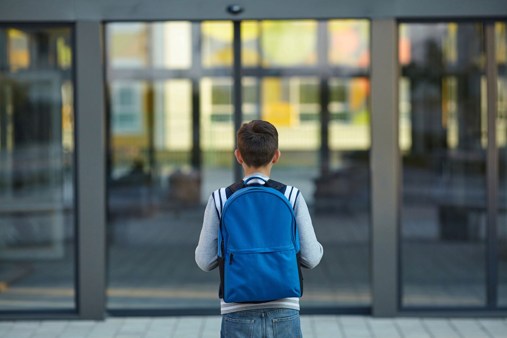 Uczeń przed drzwiami szkoły