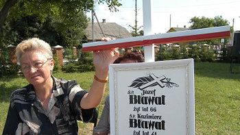 Kazimiera Szulist przy krzyżu, upamiętniającym jej wymordowaną rodzinę, m.in. ojca i dziadka