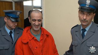 Algierczyk Mourad A. w towarzystwie policjanów opuszcza salę rozpraw krakowskiego sądu.