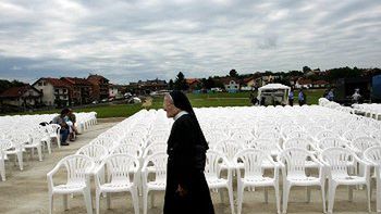 Zakonnica przechadza się wśród krzeseł, przygotowanych na papieską mszę świętą w Banja Luce